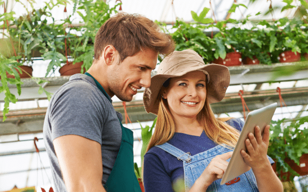 Happy people in vertical garden area with tablet